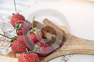 Chocolate with fresh berries on wooden table