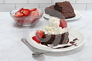 Chocolate Fudge Brownie topped with whipped cream and strawberries