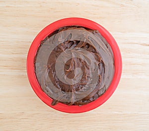 Chocolate fudge frosting in a small bowl on counter top