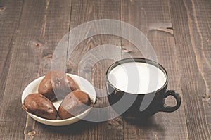 chocolate gingerbreads and milk in a black mug/chocolate gingerbreads and milk in a black mug on a dark wooden background. Select