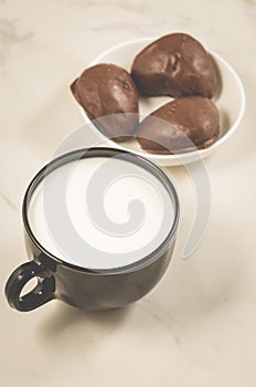 Chocolate gingerbreads and milk/chocolate gingerbreads and milk in a black mug on a white marble background
