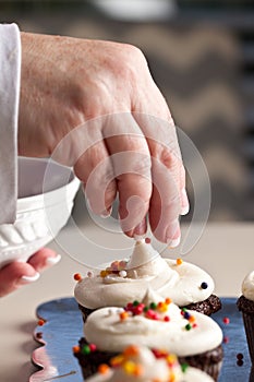 Chocolate gourmet cupcakes - putting sprinkles on