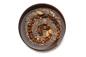 Chocolate granola cereal with nuts in a bowl background