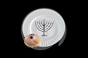 Chocolate hanukkiah with jam filled sufganiyah on a white plate