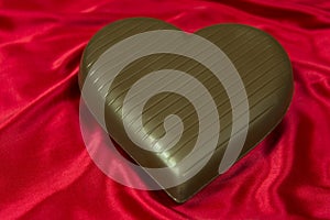 Chocolate heart on red satin