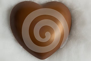 Chocolate heart resting on soft wadding photo