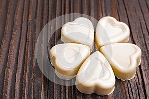 Chocolate heart-shaped candy on wooden background