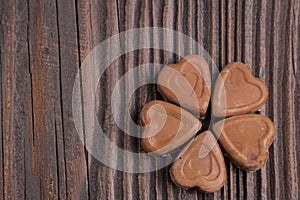 Chocolate heart-shaped candy on wooden background