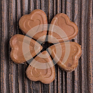 Chocolate heart-shaped candy on wooden background