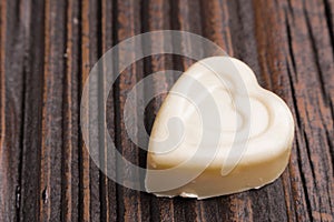 Chocolate heart-shaped candy on wooden background