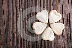 Chocolate heart-shaped candy on wooden background