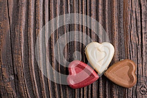 Chocolate heart-shaped candy on wooden background