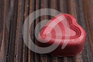 Chocolate heart-shaped candy on wooden background