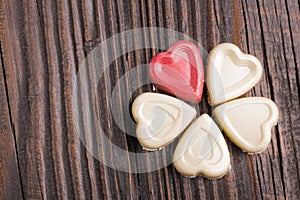 Chocolate heart-shaped candy on wooden background