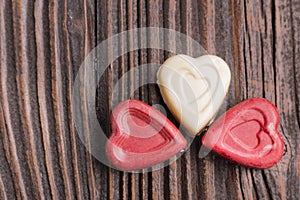 Chocolate heart-shaped candy on wooden background