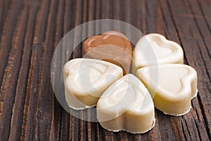 Chocolate heart-shaped candy on wooden background