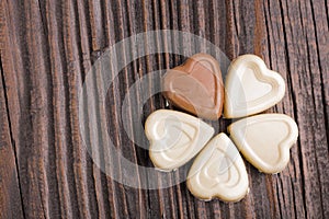 Chocolate heart-shaped candy on wooden background