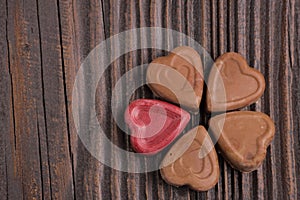 Chocolate heart-shaped candy on wooden background