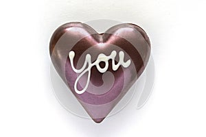 Chocolate heart shaped with word you on white background