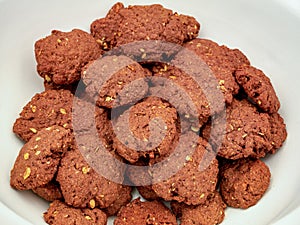 Chocolate homemade cookies with nuts, on a pile in a bowl