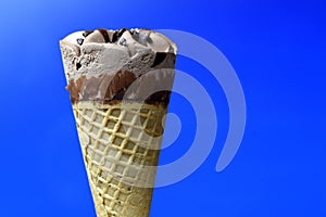 Chocolate ice cream cone on blue background