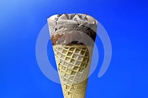 Chocolate ice cream cone on blue background photo