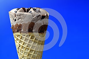 Chocolate ice cream cone on blue background photo