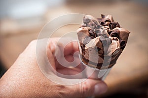 chocolate ice cream cone in hand
