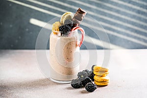 Chocolate indulgent extreme milkshake with macaroons, berry and sweets. Crazy freakshake food trend. Copy space