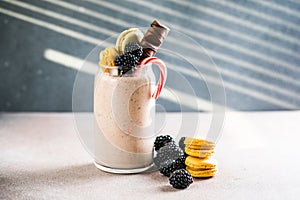 Chocolate indulgent extreme milkshake with macaroons, berry and sweets. Crazy freakshake food trend. Copy space