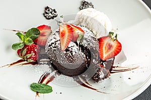 chocolate lava cake with fresh strawberries, ice-cream ball and mint, Food recipe background. Close up