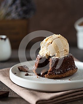 Chocolate lava cake with ice cream served on plate on dark background. Confectionery, cafe, restaurant menu, recipe, cookbook