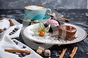 Chocolate lava cake Molten with ice cream on plate and cappuccino. Balls of ice cream in cup . Dark black background.