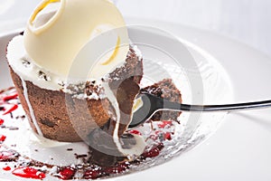 Chocolate lava cake Molten with melting ice cream, chocolate with spoon on plate and white background