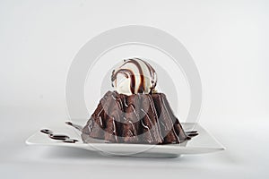 Chocolate lava cake with vanilla ice cream decorated with chocolate cream on a plate