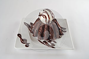 Chocolate lava cake with vanilla ice cream decorated with chocolate cream on a plate