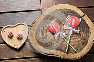 Chocolate lollipops packed next to red fruit brigadeiros