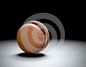 Chocolate macaron at the black background