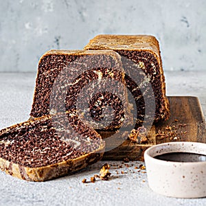 Chocolate marbled cake biscuit Zebra with chocolate icing on a wooden board on a gray background.