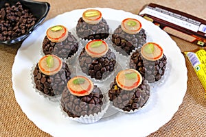 Chocolate Milk Mithai or sweets made using sweet condensed Milk and cocoa powder, garnished with choco nut.