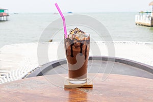 Chocolate milkshake with cherry and chantilly cream fresh brown dark in glass cup tall.