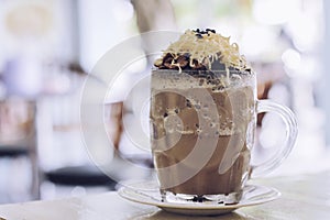 Chocolate Milkshake with chocolate cereals, cheese, and Choco chips in the big clear glass cup. Selective focus close-up on top of