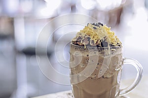 Chocolate Milkshake with chocolate cereals, cheese, and Choco chips in the big clear glass cup. Selective focus close-up on top of