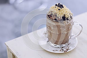 Chocolate Milkshake with chocolate cereals, cheese, and Choco chips in the big clear glass cup. Selective focus close-up on top of