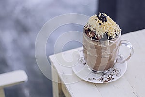 Chocolate Milkshake with chocolate cereals, cheese, and Choco chips in the big clear glass cup. Selective focus close-up on top of