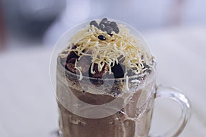 Chocolate Milkshake with chocolate cereals  cheese  and Choco chips in the big clear glass cup. Selective focus close-up on top of