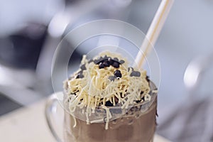 Chocolate Milkshake with chocolate cereals  cheese  and Choco chips in the big clear glass cup. Selective focus close-up on top of