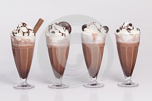 Chocolate milkshake with chunks of chocolate and cookies on top, i