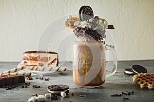 Chocolate milkshake with dripping sauce, cream, marshmallow, cookies and cake