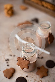 chocolate milkshake in glass bottle with gingerbread crumbly cookies